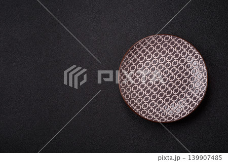 An empty ceramic round plate, kitchen utensils for a dinner table. An empty plate An empty ceramic round plate, kitchen utensils for a dinner table. An empty plate 139907485