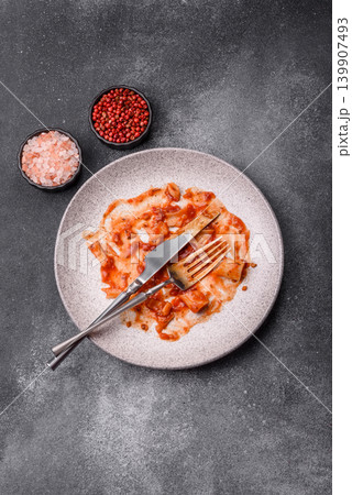 A dirty plate after a meal with leftover pasta and tomato sauce, cleaning. An empty dirty plate A dirty plate after a meal with leftover pasta and tomato sauce, cleaning. An empty dirty plate 139907493
