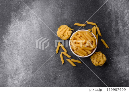 Italian uncooked dry penne regate pasta ready for cooking. Dry penne pasta 139907499