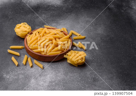 Italian uncooked dry penne regate pasta ready for cooking. Dry penne pasta 139907504