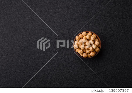 Whole peeled hazelnuts, roasted or raw, as an ingredient for healthy food. Hazelnuts as a background 139907597