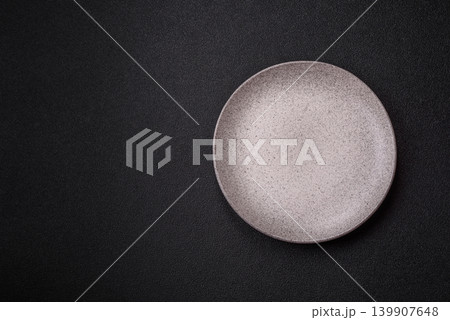 An empty ceramic round plate, kitchen utensils for a dinner table. An empty plate An empty ceramic round plate, kitchen utensils for a dinner table. An empty plate 139907648