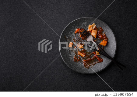 A dirty plate after a meal with leftover pasta and tomato sauce, cleaning. An empty dirty plate A dirty plate after a meal with leftover pasta and tomato sauce, cleaning. An empty dirty plate 139907654
