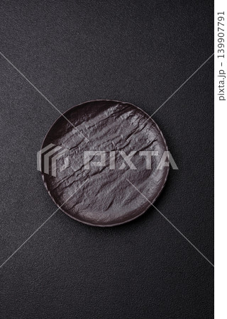 An empty ceramic round plate, kitchen utensils for a dinner table. An empty plate An empty ceramic round plate, kitchen utensils for a dinner table. An empty plate 139907791