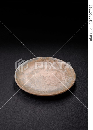 An empty ceramic round plate, kitchen utensils for a dinner table. An empty plate An empty ceramic round plate, kitchen utensils for a dinner table. An empty plate 139907796