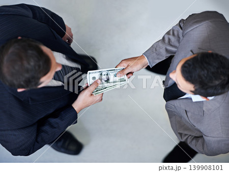 Businessman, money and bribe above with dollar bills for payment, deal or agreement at office. Top view of man, colleagues or employees giving cash, paper or exchange in bribery, scam or fraud Businessman, money and bribe above with dollar bills for payment, deal or agreement at office. Top view of man, colleagues or employees giving cash, paper or exchange in bribery, scam or fraud 139908101