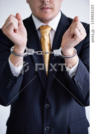 Hands, business man and handcuffs for fraud or bribery, suspicious professional deal with justice or jail. Crime, corruption or money laundering, shackles for prison with thief or criminal in finance Hands, business man and handcuffs for fraud or bribery, suspicious professional deal with justice or jail. Crime, corruption or money laundering, shackles for prison with thief or criminal in finance 139908105