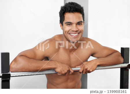 Portrait, fitness and smile with shirtless man in gym for bodybuilding, health or physical workout. Exercise, training or weightlifting and happy young bodybuilder athlete with bench press equipment Portrait, fitness and smile with shirtless man in gym for bodybuilding, health or physical workout. Exercise, training or weightlifting and happy young bodybuilder athlete with bench press equipment 139908161
