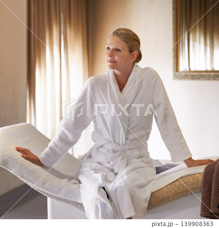 Woman, thinking and happy for spa treatment and wellness in robe, luxury and health on massage table or chair. Person or client relax in thoughtful expression, waiting and ready for holistic therapy 139908363
