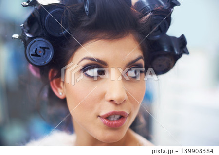Woman, face and hair curlers with makeup for beauty in salon with haircare, self care or cosmetology. Model, person or hairstyle for morning routine, curling or getting ready for wellness or grooming Woman, face and hair curlers with makeup for beauty in salon with haircare, self care or cosmetology. Model, person or hairstyle for morning routine, curling or getting ready for wellness or grooming 139908384