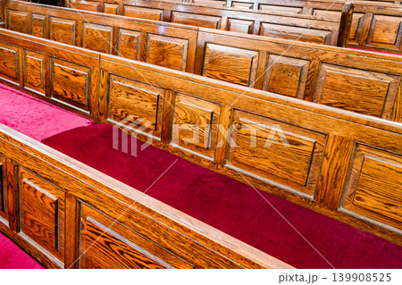 rows of wooden seats for parishioners in a Catholic church close-up rows of wooden seats for parishioners in a Catholic church close-up 139908525