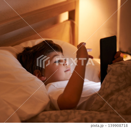 Child, tablet and bedroom with night, smile and technology for social media or learning. Boy, bed and connectivity for knowledge, growth and elearning or internet surfing at home with touchscreen 139908718