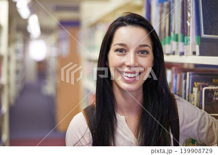 Smile, student and portrait of woman in library for studying at university for test, exam or assignment. Happy, education and confident young female person by books at college campus or academy. 139908729