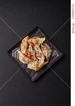Gyoza, Chinese or Japanese meat dumplings, is an Asian food with hot peppers. Gyoza with meat Gyoza, Chinese or Japanese meat dumplings, is an Asian food with hot peppers. Gyoza with meat 139909152