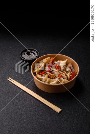Gyoza, Chinese or Japanese meat dumplings, is an Asian food with hot peppers. Gyoza with meat Gyoza, Chinese or Japanese meat dumplings, is an Asian food with hot peppers. Gyoza with meat 139909170