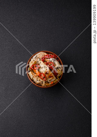 Gyoza, Chinese or Japanese meat dumplings, is an Asian food with hot peppers. Gyoza with meat Gyoza, Chinese or Japanese meat dumplings, is an Asian food with hot peppers. Gyoza with meat 139909199