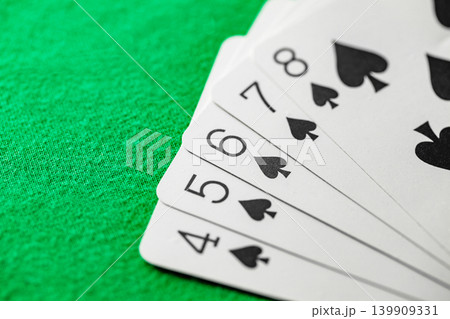 straight flush of spades from playing cards in poker on green cloth straight flush of spades from playing cards in poker on green cloth 139909331