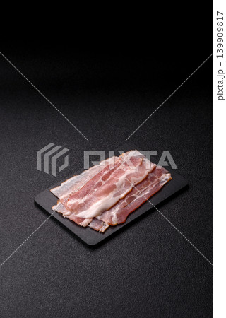 Raw fresh bacon slices with layers of meat or prosciutto with salt and spices. Raw bacon Raw fresh bacon slices with layers of meat or prosciutto with salt and spices. Raw bacon 139909817