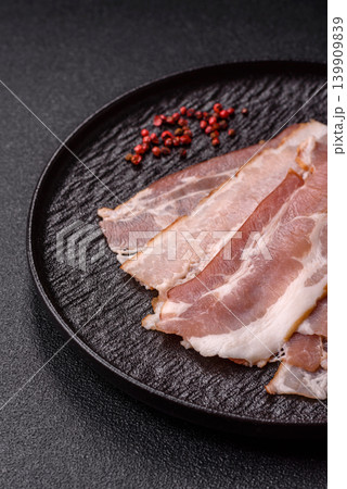 Raw fresh bacon slices with layers of meat or prosciutto with salt and spices. Raw bacon Raw fresh bacon slices with layers of meat or prosciutto with salt and spices. Raw bacon 139909839