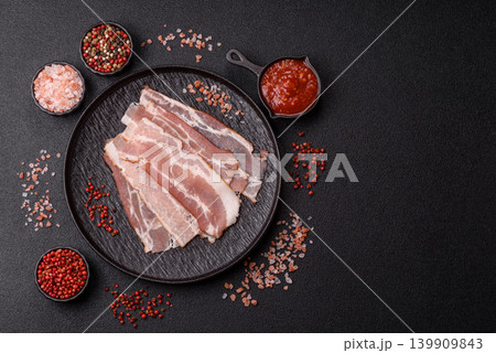 Raw fresh bacon slices with layers of meat or prosciutto with salt and spices. Raw bacon Raw fresh bacon slices with layers of meat or prosciutto with salt and spices. Raw bacon 139909843