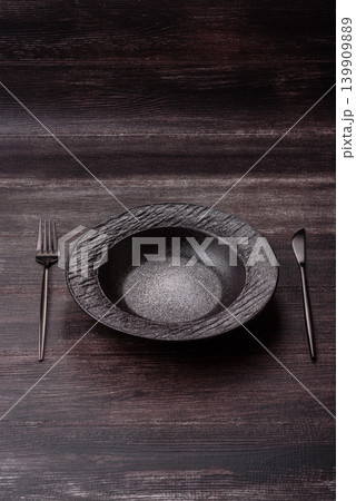 An empty ceramic round plate, kitchen utensils for a dinner table. An empty plate An empty ceramic round plate, kitchen utensils for a dinner table. An empty plate 139909889