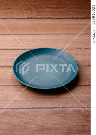 An empty ceramic round plate, kitchen utensils for a dinner table. An empty plate An empty ceramic round plate, kitchen utensils for a dinner table. An empty plate 139910023
