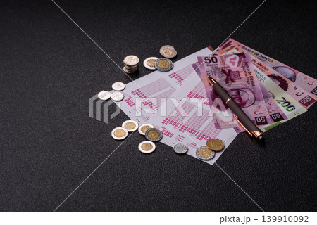Lottery ticket, Mexican banknotes, and a pen, chance to win big, gambling. Lottery ticket Lottery ticket, Mexican banknotes, and a pen, chance to win big, gambling. Lottery ticket 139910092