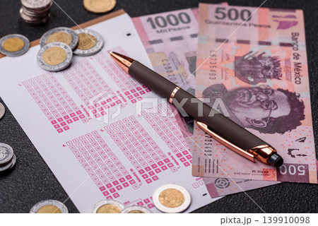 Lottery ticket, Mexican banknotes, and a pen, chance to win big, gambling. Lottery ticket 139910098