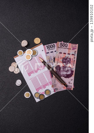 Lottery ticket, Mexican banknotes, and a pen, chance to win big, gambling. Lottery ticket Lottery ticket, Mexican banknotes, and a pen, chance to win big, gambling. Lottery ticket 139910102