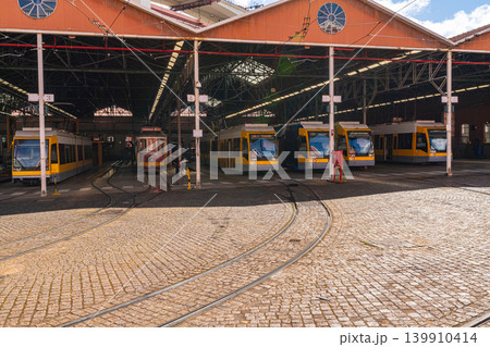 Tram depot with multiple trains under industrial hangar in Lisbon Tram depot with multiple trains under industrial hangar in Lisbon 139910414