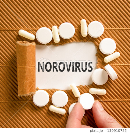Norovirus medical words symbol. Concept words Norovirus on beautiful white paper. Beautiful brown background. Beautiful white pills. Doctor hand. Medical Norovirus concept. Copy space. 139910725