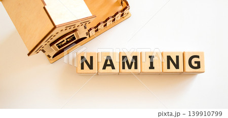 Naming or name symbol. Concept word Naming on beautiful wooden blocks. Beautiful white background. Beautiful wooden model of house. Business naming or name concept. Copy space. Naming or name symbol. Concept word Naming on beautiful wooden blocks. Beautiful white background. Beautiful wooden model of house. Business naming or name concept. Copy space. 139910799
