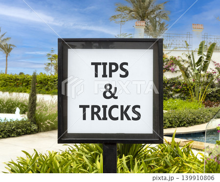 Tips and tricks words symbol. Concept words Tips and tricks on beautiful white sign. Beautiful hotel garden blue sky background. Business tips and tricks motivational support concept. Copy space. 139910806
