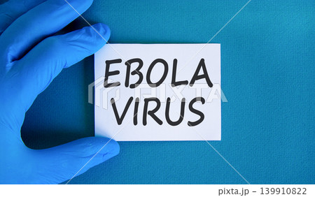 Ebola virus medical words symbol. Concept words Ebola virus on beautiful white paper. Beautiful blue background. Doctor hand. Medical Ebola virus concept. Copy space. Ebola virus medical words symbol. Concept words Ebola virus on beautiful white paper. Beautiful blue background. Doctor hand. Medical Ebola virus concept. Copy space. 139910822