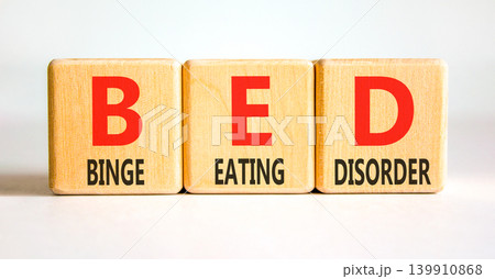 BED binge eating disorder symbol. Concept words BED binge eating disorder on beautiful wooden blocks. Beautiful white background. Medical BED binge eating disorder concept. Copy space. BED binge eating disorder symbol. Concept words BED binge eating disorder on beautiful wooden blocks. Beautiful white background. Medical BED binge eating disorder concept. Copy space. 139910868