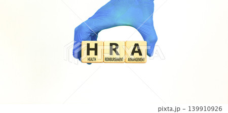 HRA health reimbursement arrangement symbol. Concept words HRA health reimbursement arrangement on beautiful wooden blocks. Doctor hand. Beautiful white background. Medical HRA concept. Copy space. 139910926