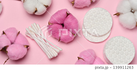 Round cotton pads on a soft pink background, close-up of hygiene products for daily skin care Round cotton pads on a soft pink background, close-up of hygiene products for daily skin care 139911263