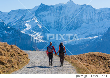 アルプスの山々を歩くハイカーの後ろ姿。グリンデルワルト、ベルン州、スイス アルプスの山々を歩くハイカーの後ろ姿。グリンデルワルト、ベルン州、スイス 139911441