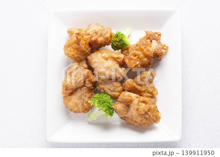 揚げた鶏肉とブロッコリーを白い皿に盛り付けた、香ばしい唐揚げ 139911950
