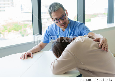 医師から告知を受け悲しむ女性 139912213