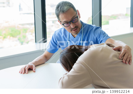 医師から告知を受け悲しむ女性 139912214