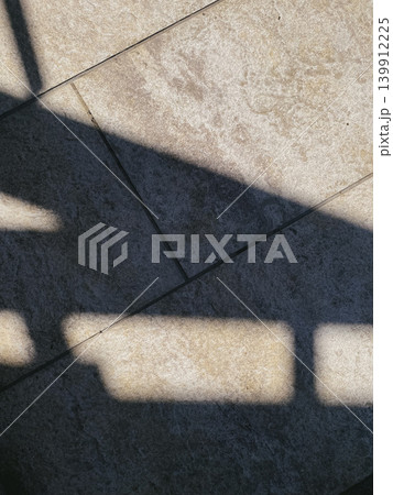 Shadows on textured stone surface, abstract geometric pattern. Light and shadow, contrast, composition. Minimalist, everyday materials. Ideal for backgrounds or textures Shadows on textured stone surface, abstract geometric pattern. Light and shadow, contrast, composition. Minimalist, everyday materials. Ideal for backgrounds or textures 139912225