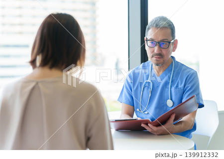 医師から説明を受ける女性 医師から説明を受ける女性 139912332