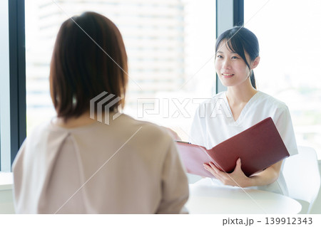 医師から説明を受ける女性 医師から説明を受ける女性 139912343