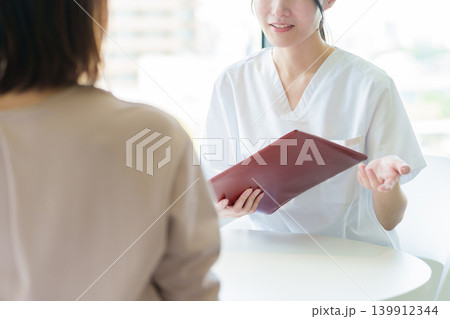 医師から説明を受ける女性 医師から説明を受ける女性 139912344