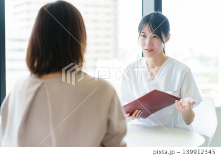 医師から説明を受ける女性 139912345