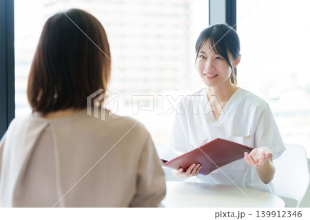 医師から説明を受ける女性 医師から説明を受ける女性 139912346