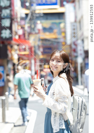 横浜中華街で食べ歩きを楽しむ女性 横浜中華街で食べ歩きを楽しむ女性 139912593