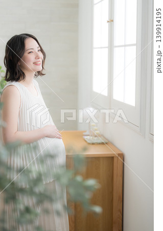 笑顔でお腹に手を添える日本人女性の妊婦さん、マタニティライフスタイルイメージの笑顔 笑顔でお腹に手を添える日本人女性の妊婦さん、マタニティライフスタイルイメージの笑顔 139914195