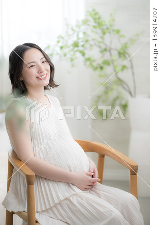 笑顔でお腹に手を添える日本人女性の妊婦さん、マタニティライフスタイルイメージの笑顔 笑顔でお腹に手を添える日本人女性の妊婦さん、マタニティライフスタイルイメージの笑顔 139914207